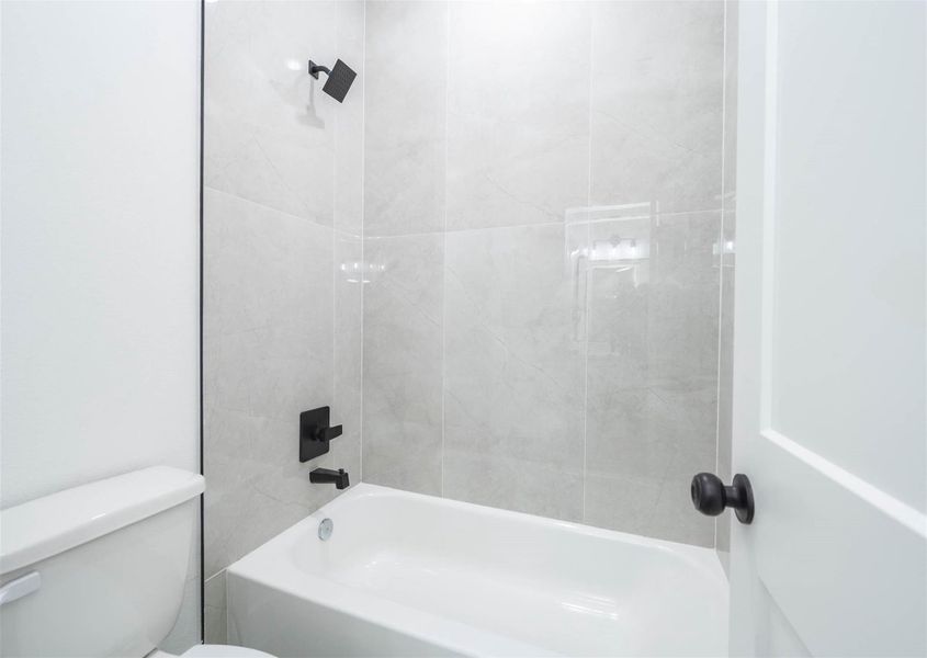 Modern shower and bath combination with sleek tilework and stylish fixtures.