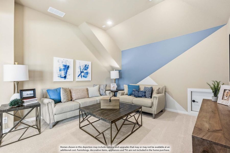 Living room with vaulted ceiling, blue geometric accent wall, and beige sectional sofa with blue pillows