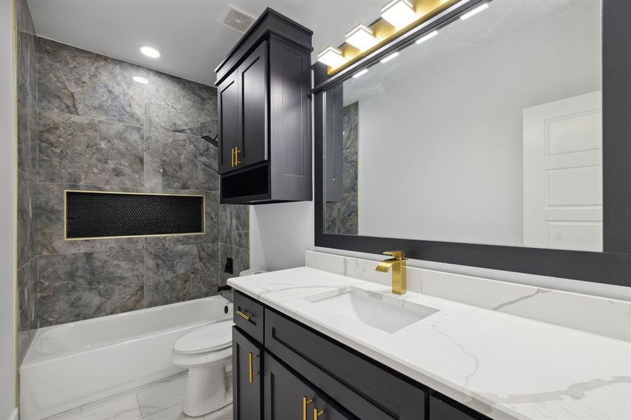 Full bathroom featuring vanity, toilet, and tiled shower / bath