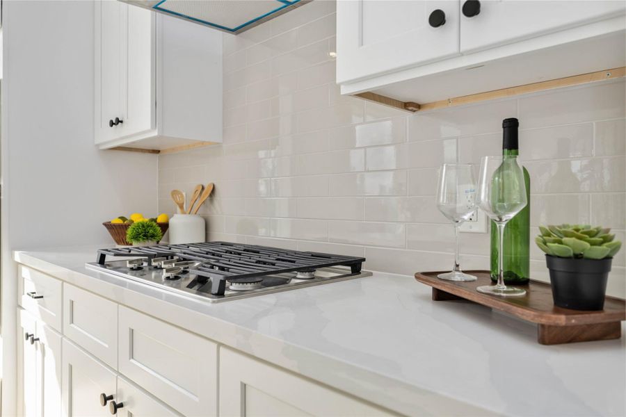 The countertop in the photo appears to be a polished white quartz surface, characterized by its bright, clean finish and subtle, soft veining that adds a modern and elegant touch to the kitchen.