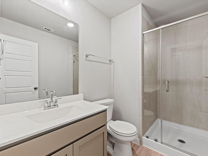 Full bathroom with walk-in shower and modern finishes.