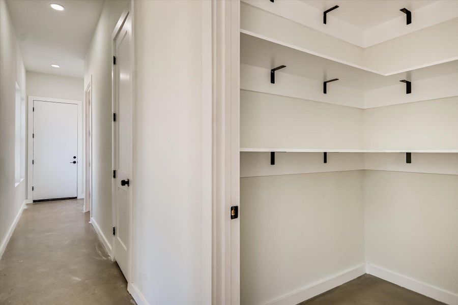 Hall with finished concrete flooring and recessed lighting
