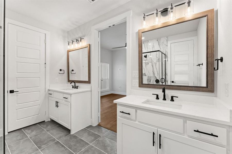 Bathroom featuring vanity, tile patterned floors, and a shower with door