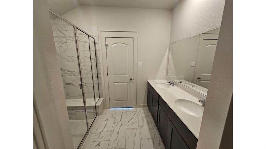 Bathroom featuring a spacious walk-in shower with glass enclosure, white tile surround, and built-in bench Bathroom featuring a spacious walk-in shower with glass enclosure, white tile surround, and built-in bench