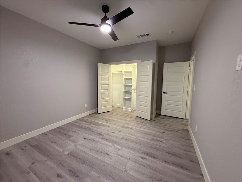 Unfurnished bedroom with ceiling fan, light wood finished floors, and a closet