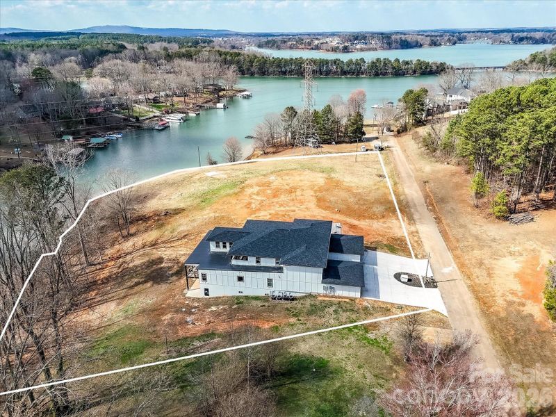 Aerial view of the property showcasing its prime location on a peaceful cove just off Lake Norman with expansive surrounding land.