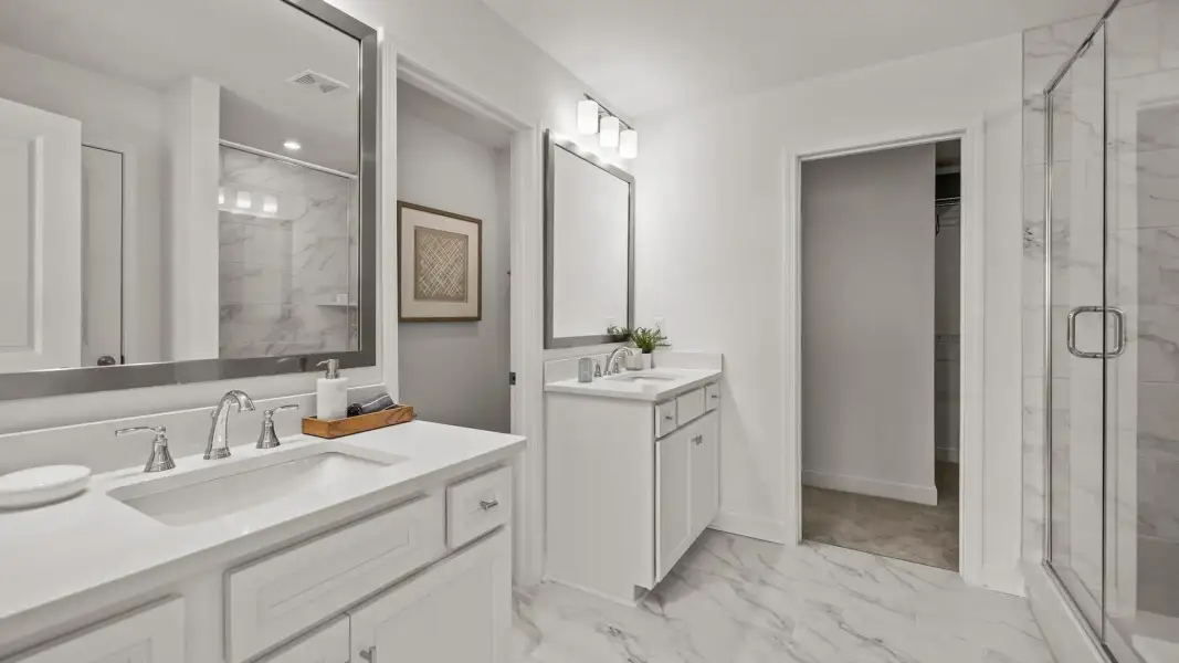 Spa-inspired primary bathroom with separate comfort height vanities and high-end finishes in the Townsend Design by DRB Homes Spa-inspired primary bathroom with separate comfort height vanities and high-end finishes in the Townsend Design by DRB Homes