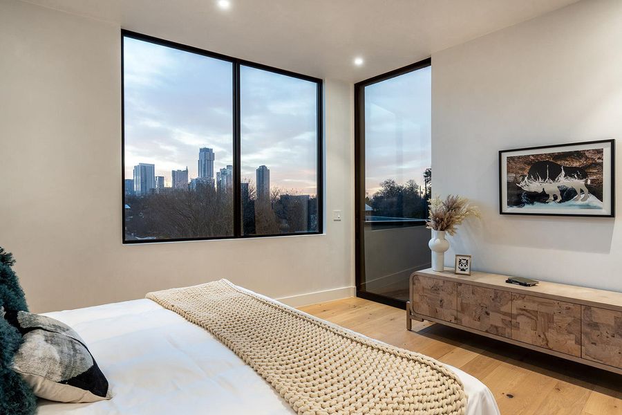 Floor-to-ceiling windows offer captivating city views in this bright bedroom. Floor-to-ceiling windows offer captivating city views in this bright bedroom.