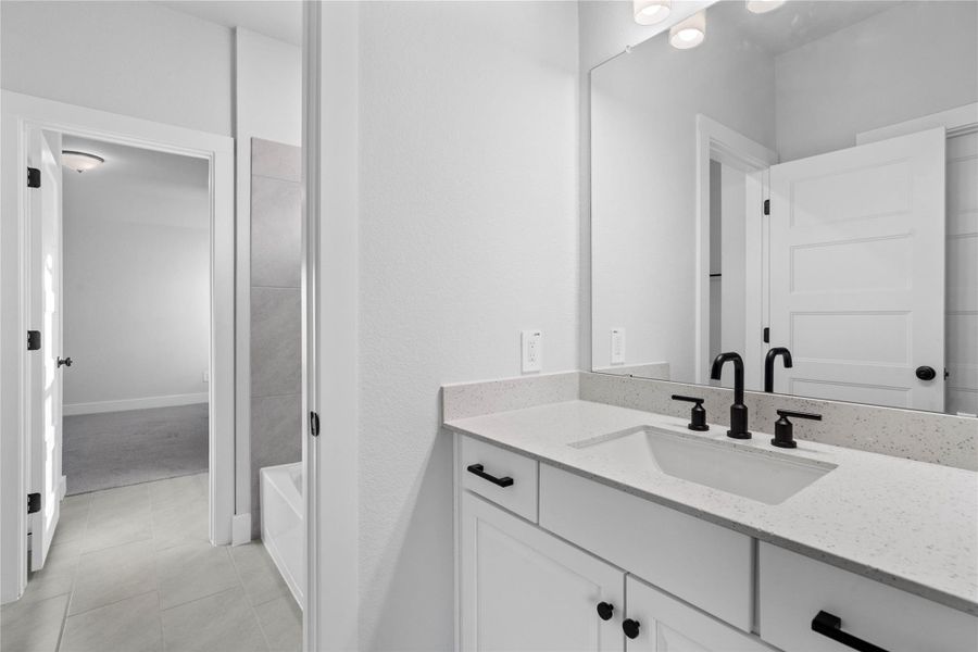 Jack and Jill bathroom provides private en suite access from two secondary bedrooms, featuring a modern dual vanity, and tub/shower combination with tile surround.