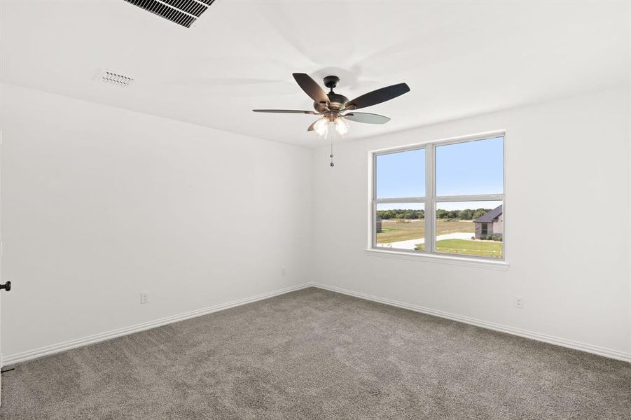 Carpeted spare room with baseboards and ceiling fan Carpeted spare room with baseboards and ceiling fan