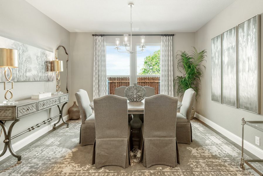 Formal dining room with six upholstered chairs, chandelier, and patterned area rug