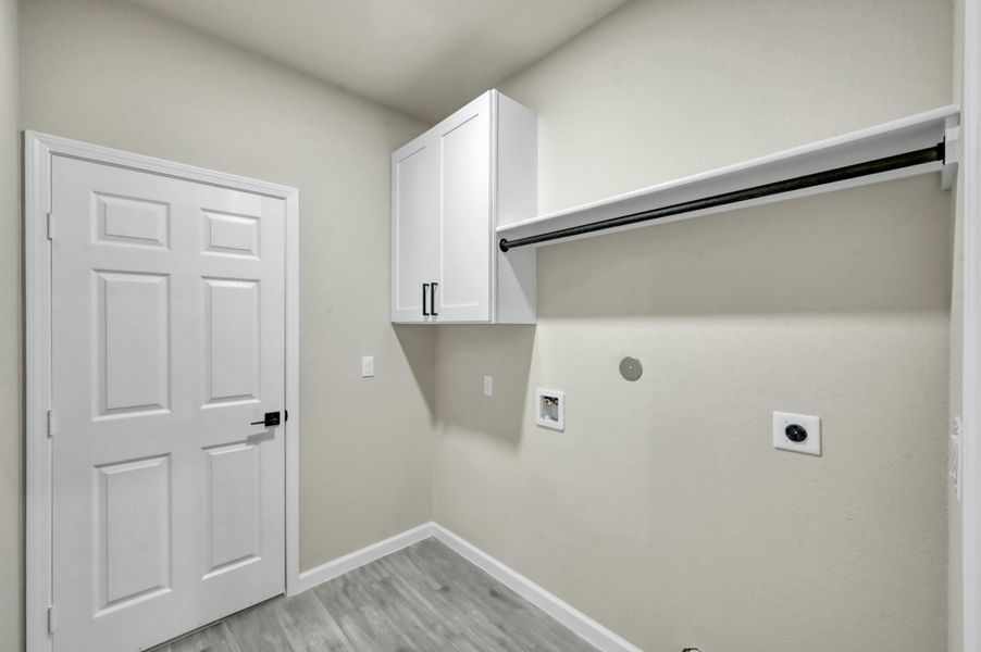 Function meets style in the dedicated laundry room, complete with custom shaker cabinetry for storage and a built-in drying rod for added convenience.