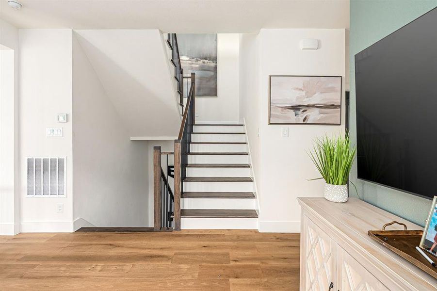 Stairway with wood finished floors and baseboards