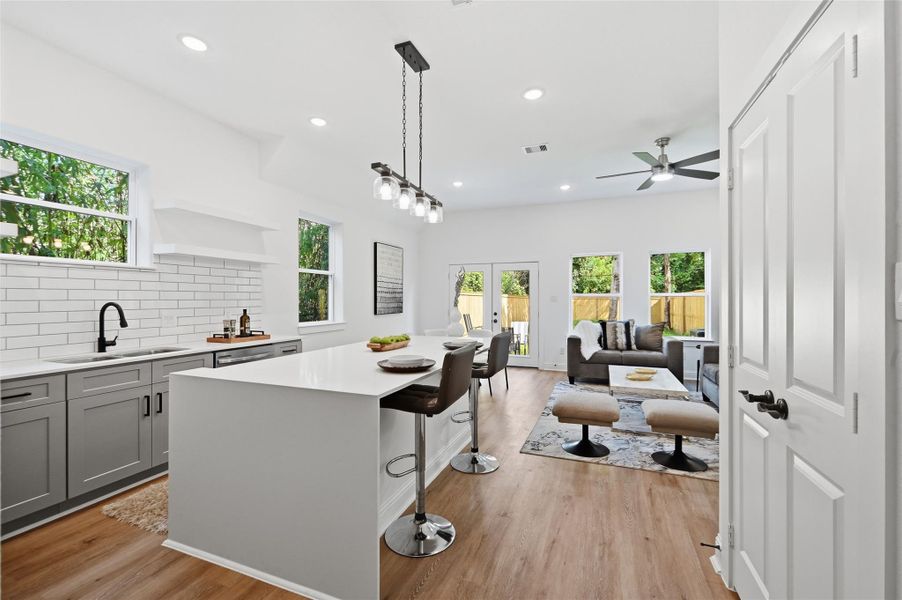 Open concept kitchen, dining and living room, with lots of natural light.