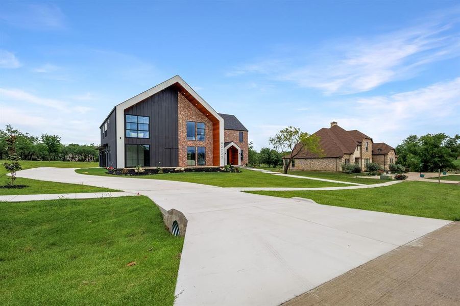 Modern architectural residence featuring a prominent gabled roofline and a multi-material facade Modern architectural residence featuring a prominent gabled roofline and a multi-material facade