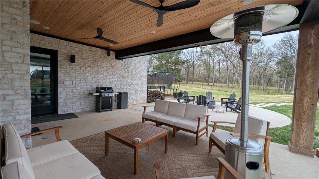 View of patio / terrace featuring a trampoline, outdoor lounge area, grilling area, and a ceiling fan
