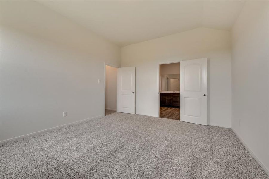 Spare room featuring vaulted ceiling and carpet floors