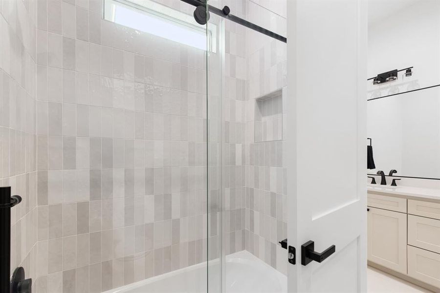 Bathroom featuring vanity and combined bath / shower with glass door