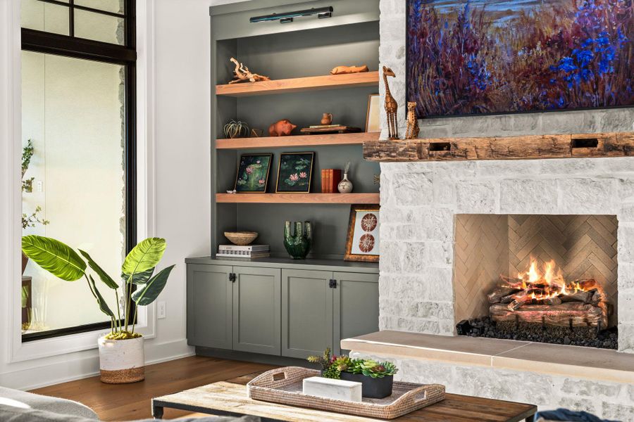 Detailed view of wood finished floors, a lit fireplace, and built in shelves Detailed view of wood finished floors, a lit fireplace, and built in shelves