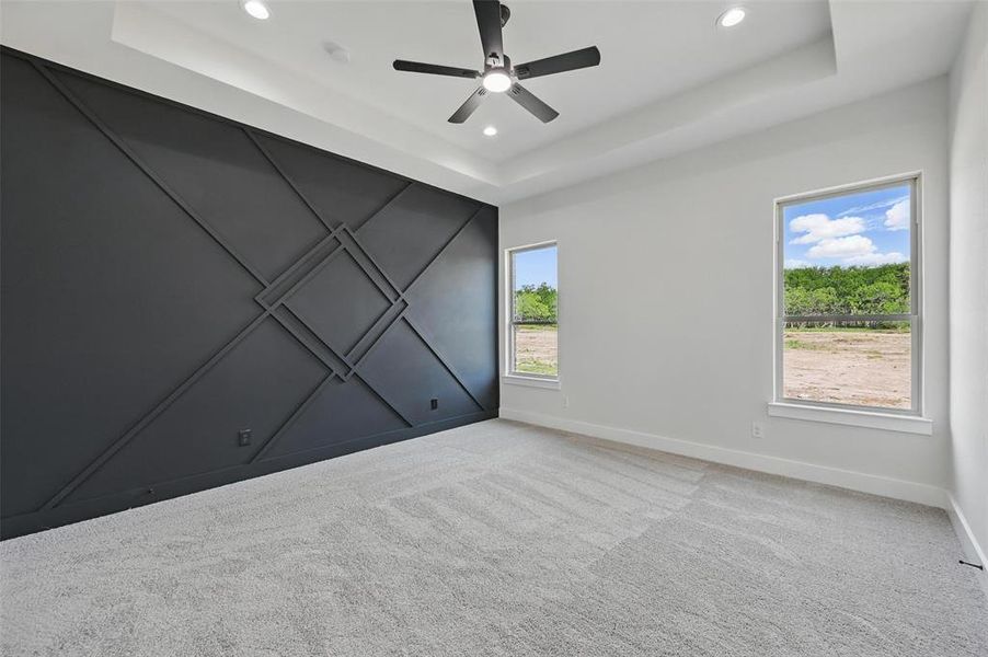 Unfurnished room featuring a raised ceiling, plenty of natural light, recessed lighting, and baseboards Unfurnished room featuring a raised ceiling, plenty of natural light, recessed lighting, and baseboards