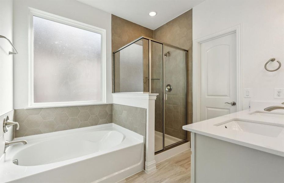 Elegant owner's bathroom with dual vanity and oversized shower*real home pictured