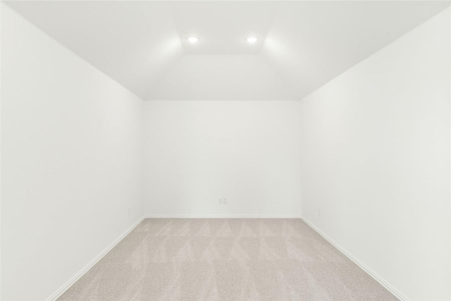 Empty room with vaulted ceiling, recessed lighting, and beige carpet Empty room with vaulted ceiling, recessed lighting, and beige carpet