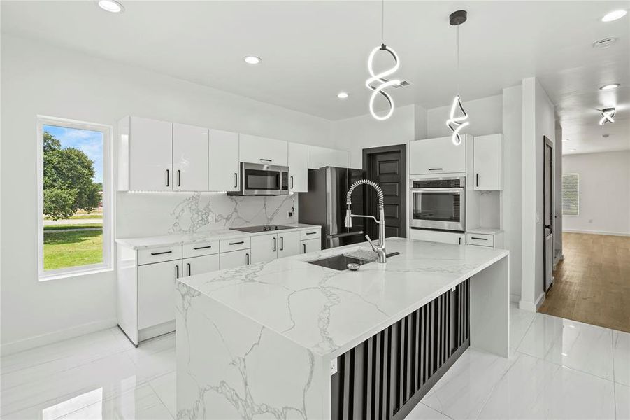 Kitchen featuring stainless steel appliances, recessed lighting, tasteful backsplash, white cabinetry, and a center island with sink Kitchen featuring stainless steel appliances, recessed lighting, tasteful backsplash, white cabinetry, and a center island with sink