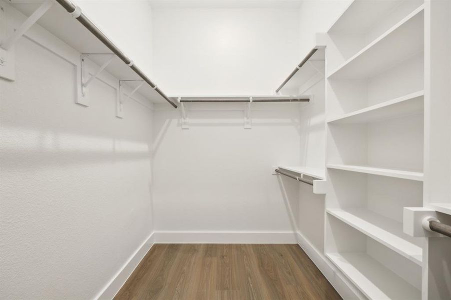 Community Representation- Walk in Primary closet with dark wood-style floors