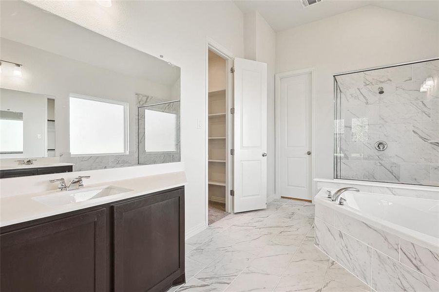 Bathroom featuring tile patterned flooring, plus walk in shower, and vanity