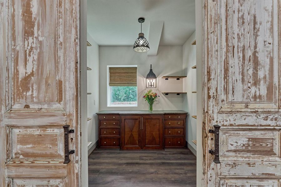 Distressed barn doors create a striking focal point as they lead into the oversized walk-in pantry