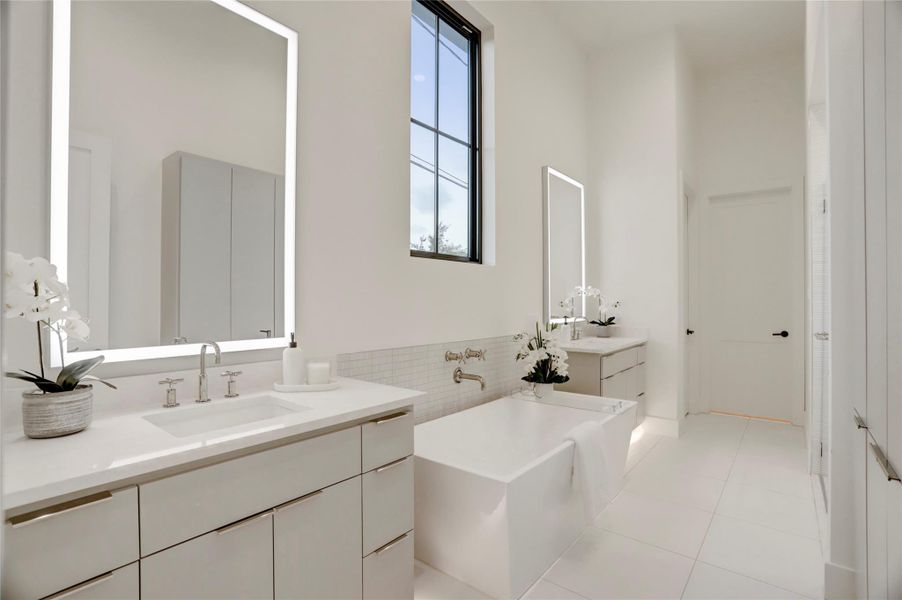 The primary bathroom also features toe kick lighting under each vanity, a large soaking tub, separate shower, built-in linen/medicine storage, and leads to a dream closet.