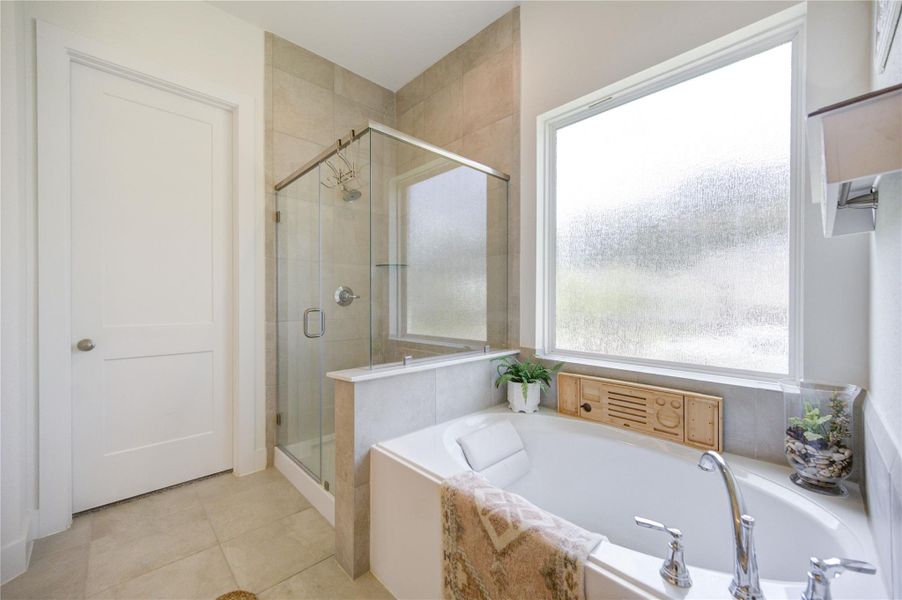 Enjoy a large soaking tub positioned beneath a window that fills the space with natural light Enjoy a large soaking tub positioned beneath a window that fills the space with natural light