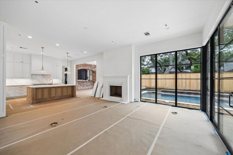Kitchen and adjacent dining room, with a bar just off the dining area featuring a charming exposed brick arch. Pictured April 2026.
