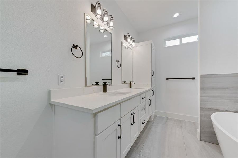 Full bath featuring double vanity, a freestanding bath, recessed lighting, and light tile patterned flooring Full bath featuring double vanity, a freestanding bath, recessed lighting, and light tile patterned flooring
