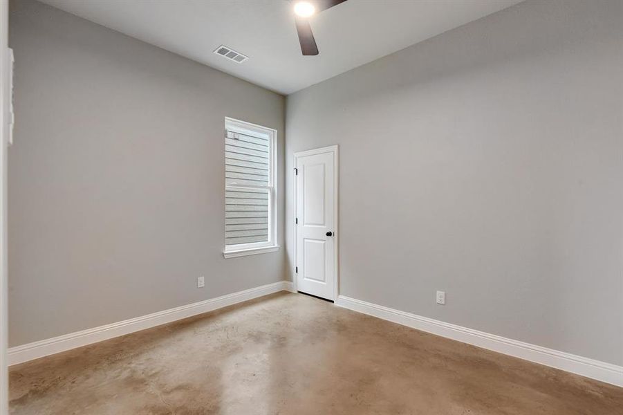 Empty room with finished concrete flooring and a ceiling fan