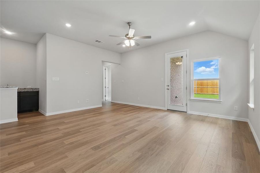 Unfurnished living room with a ceiling fan, recessed lighting, light wood-style flooring, baseboards, and lofted ceiling Unfurnished living room with a ceiling fan, recessed lighting, light wood-style flooring, baseboards, and lofted ceiling