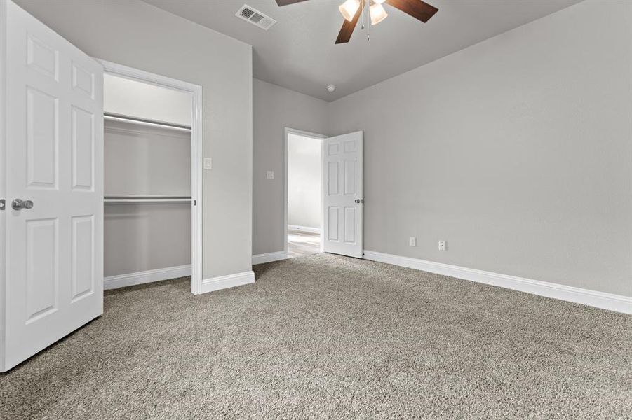 Unfurnished bedroom featuring carpet, baseboards, a closet, and ceiling fan Unfurnished bedroom featuring carpet, baseboards, a closet, and ceiling fan