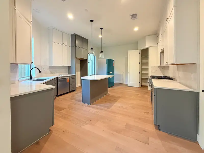 This stunning open-concept gourmet kitchen is perfect for entertaining, featuring top-tier Thermador appliances, including a professional six-burner stove. A center island offers dining and prep space, while a large picture window bathes the space in natural light.