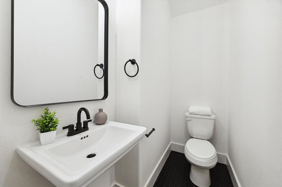 A conveniently located half-bath just off the kitchen provides easy access for residents and guests, thoughtfully tucked away for added privacy.