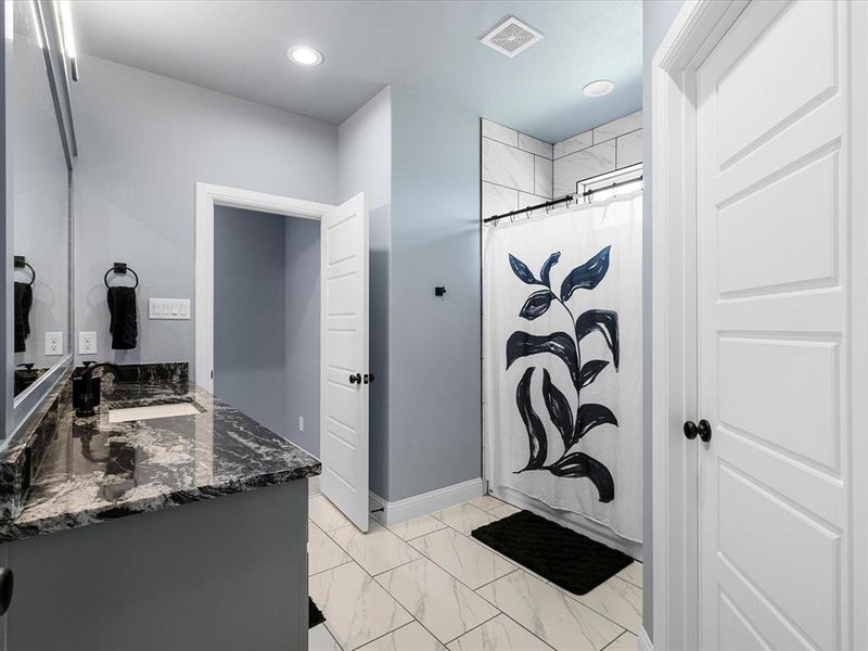 Bathroom with vanity, light marble finish floors, a shower with shower curtain, and recessed lighting Bathroom with vanity, light marble finish floors, a shower with shower curtain, and recessed lighting
