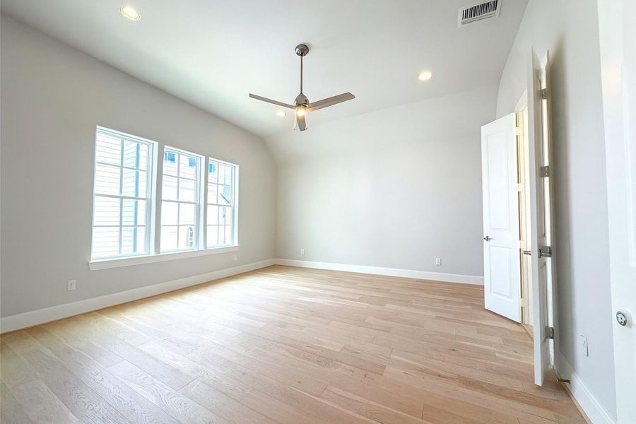 LARGE 15x18 primary bedroom with wood floors.