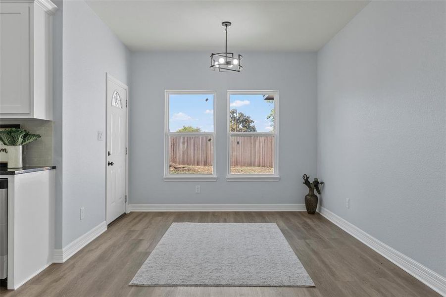 Unfurnished dining area with light wood-type flooring and a chandelier