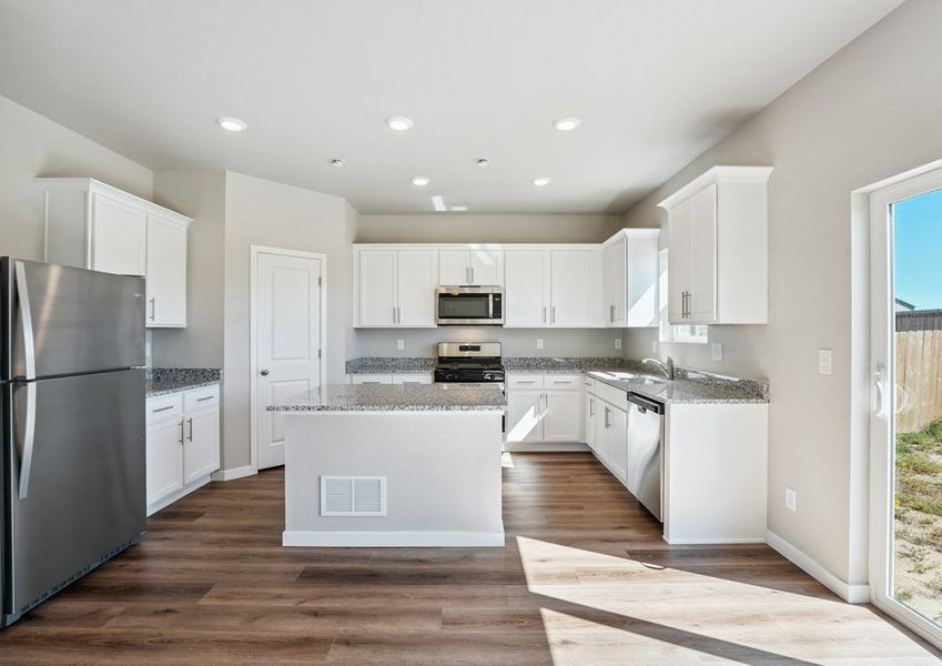 The kitchen has stainless steel appliances and plank flooring. The kitchen has stainless steel appliances and plank flooring.