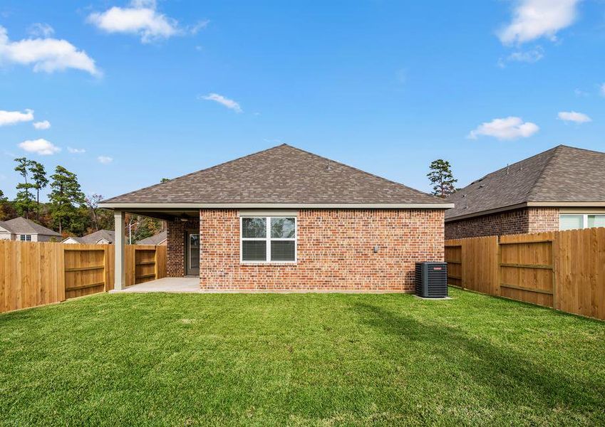 A backyard with landscaping and a large covered patio