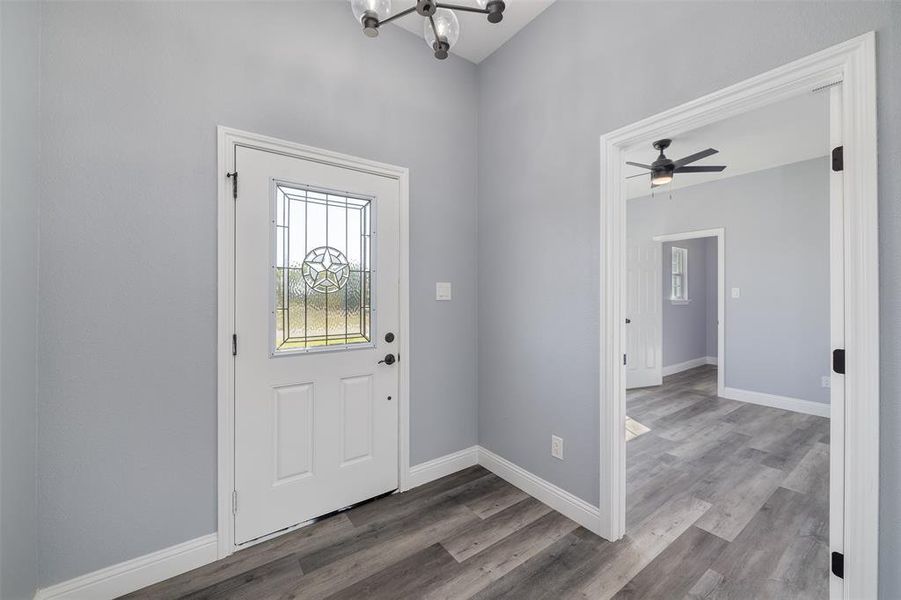 Foyer with a chandelier, wood finished floors, and a ceiling fan Foyer with a chandelier, wood finished floors, and a ceiling fan