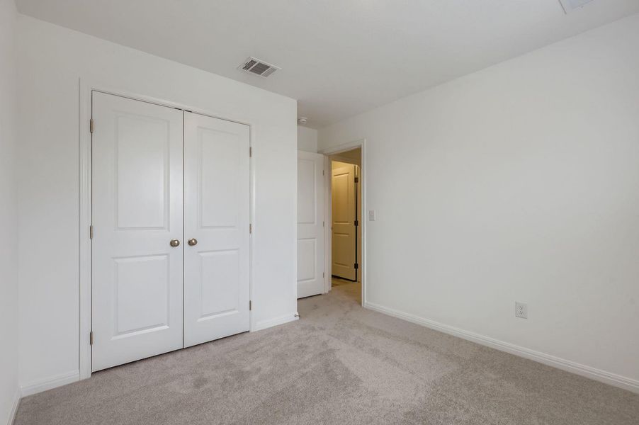 Unfurnished bedroom with carpet and a closet Unfurnished bedroom with carpet and a closet