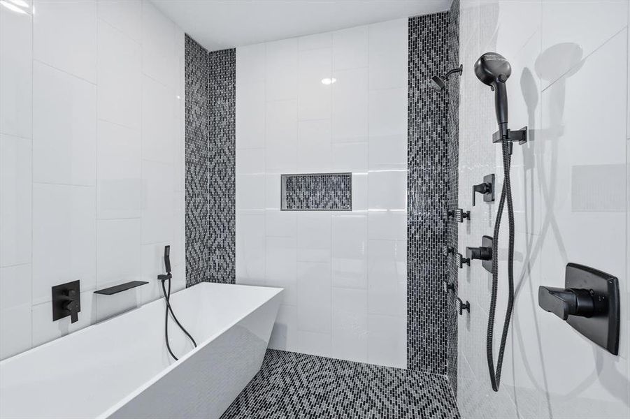 Full bathroom featuring tile walls, a freestanding tub, and a tile shower