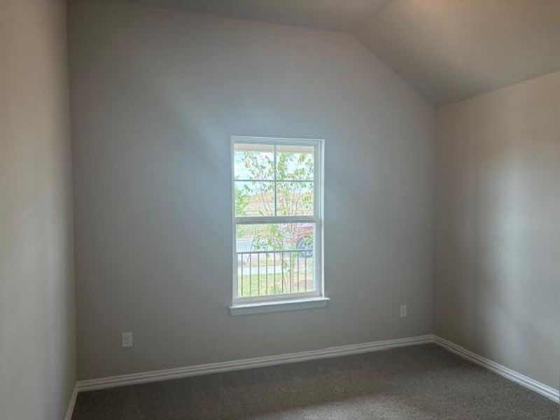 Unfurnished room featuring carpet and vaulted ceiling Unfurnished room featuring carpet and vaulted ceiling