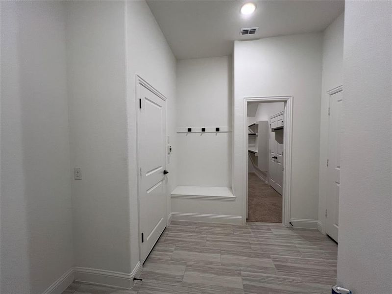 The garage entry with sitting area, clothes bar, and ceramic flooring The garage entry with sitting area, clothes bar, and ceramic flooring