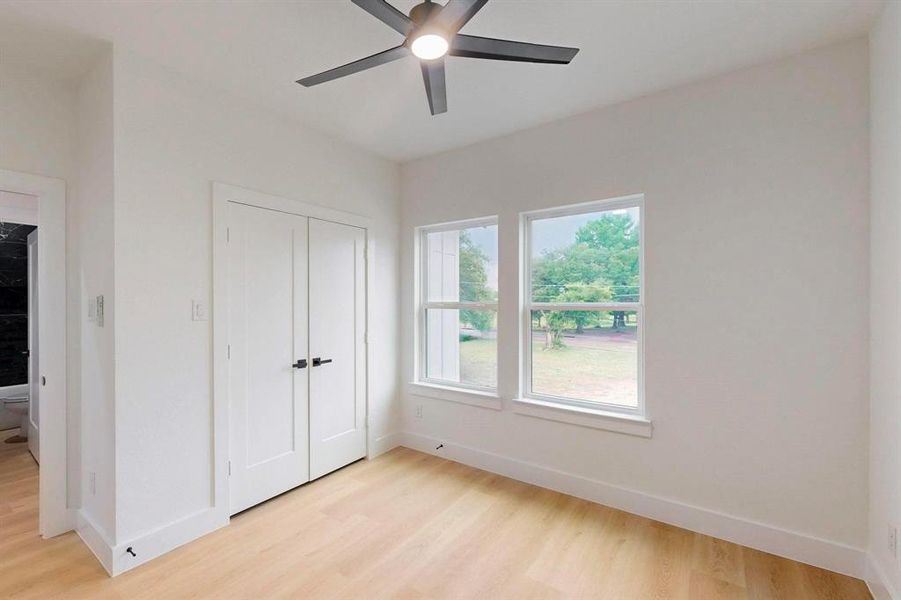 Unfurnished bedroom featuring light wood-type flooring, a closet, and ceiling fan Unfurnished bedroom featuring light wood-type flooring, a closet, and ceiling fan